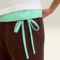 Close-up of the mint elastic contrast waistband and side drawstring on The Moment After Pants